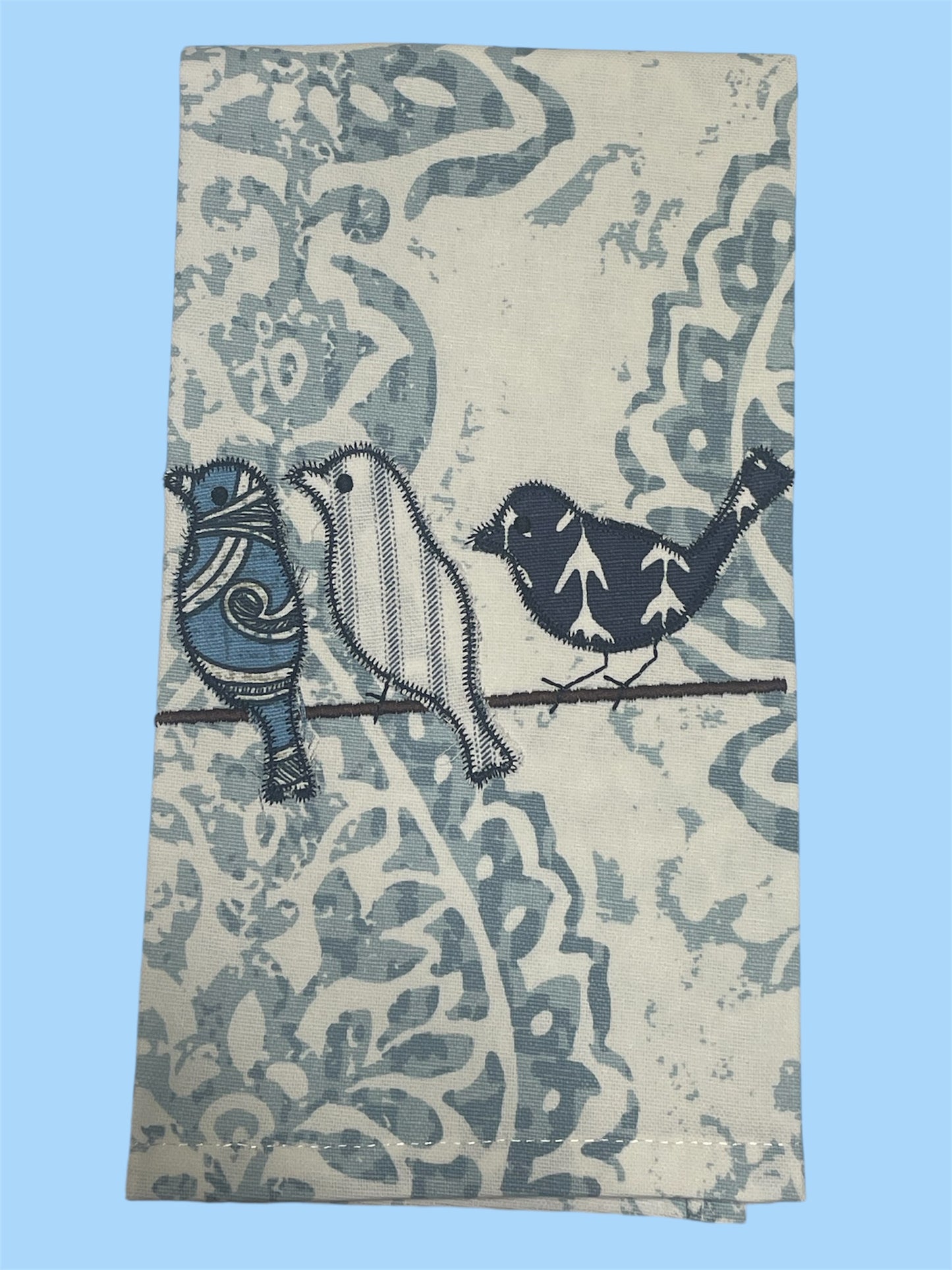 Decorative hand towel featuring embroidered blue birds on a branch with floral patterned background, perfect for spring and farmhouse-style kitchen decor.