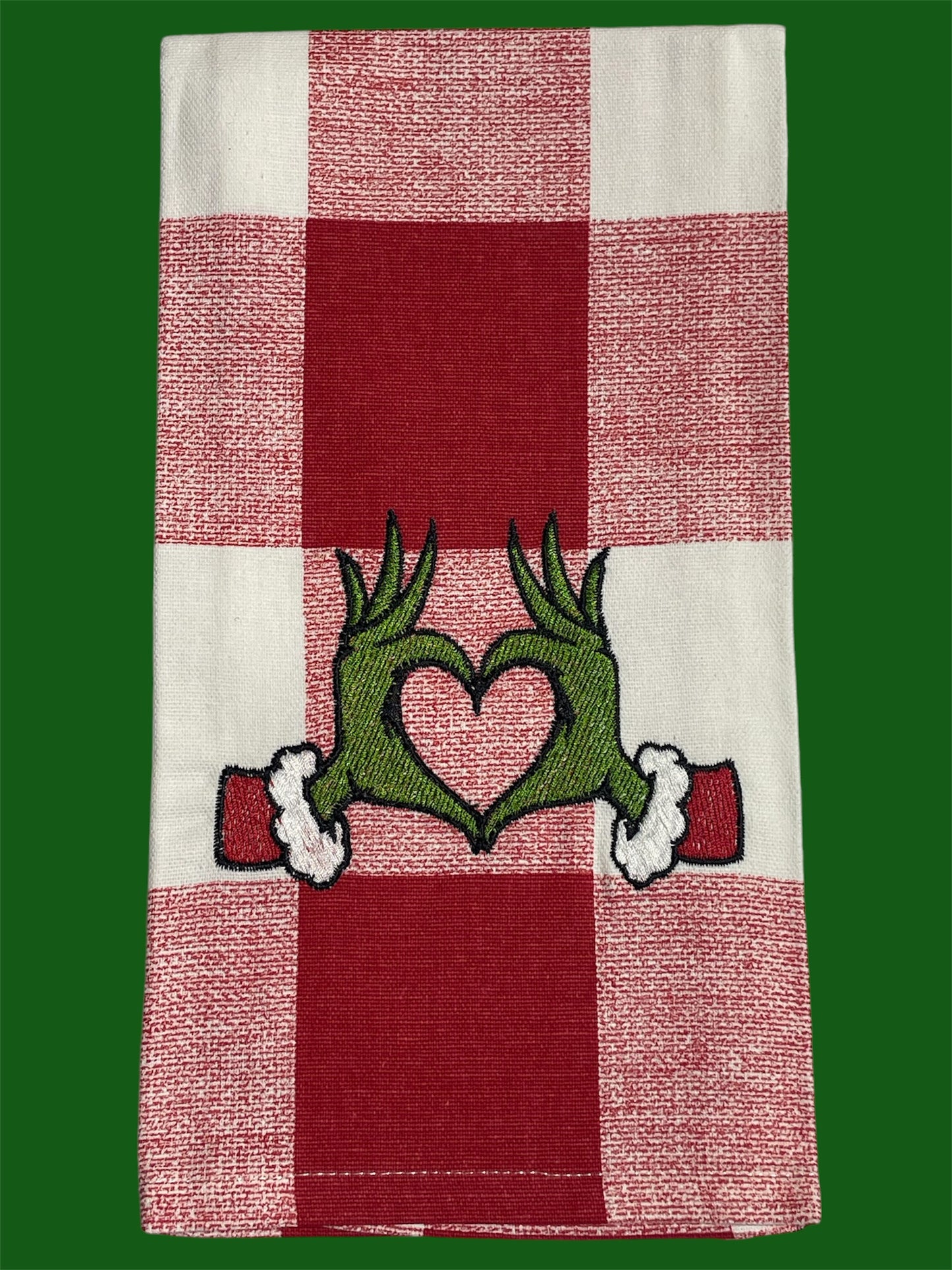 Decorative hand towel featuring embroidered Grinch-inspired green hands forming a heart on red and white checkered background, perfect for Christmas holiday decor.
