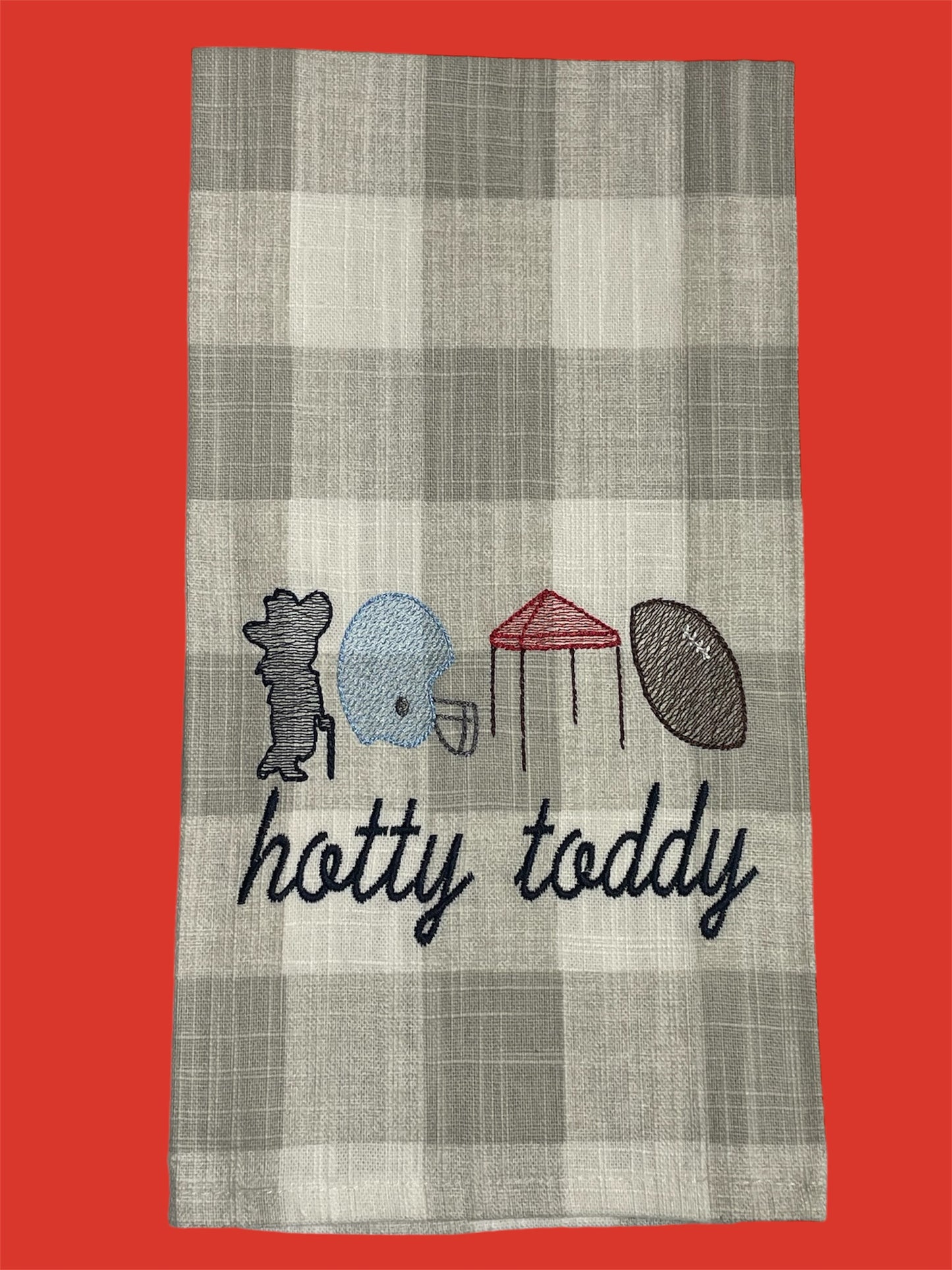 Decorative hand towel featuring embroidered Hotty Toddy design with Colonel Rebel, football helmet, tent, and football on a neutral plaid background, perfect for Ole Miss tailgating and football season decor.