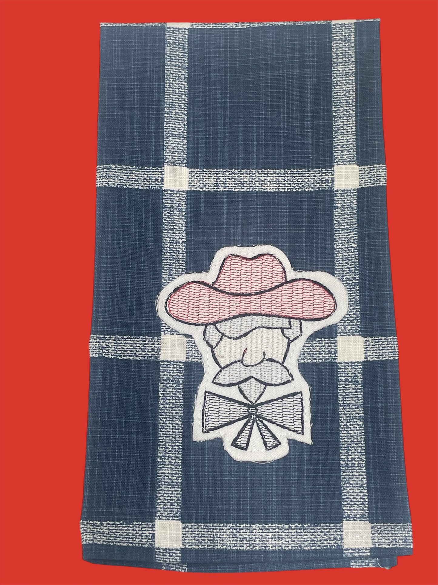 Decorative hand towel featuring embroidered Colonel Rebel mascot in pink and white on a navy blue plaid background, perfect for Ole Miss fans and Southern home decor.