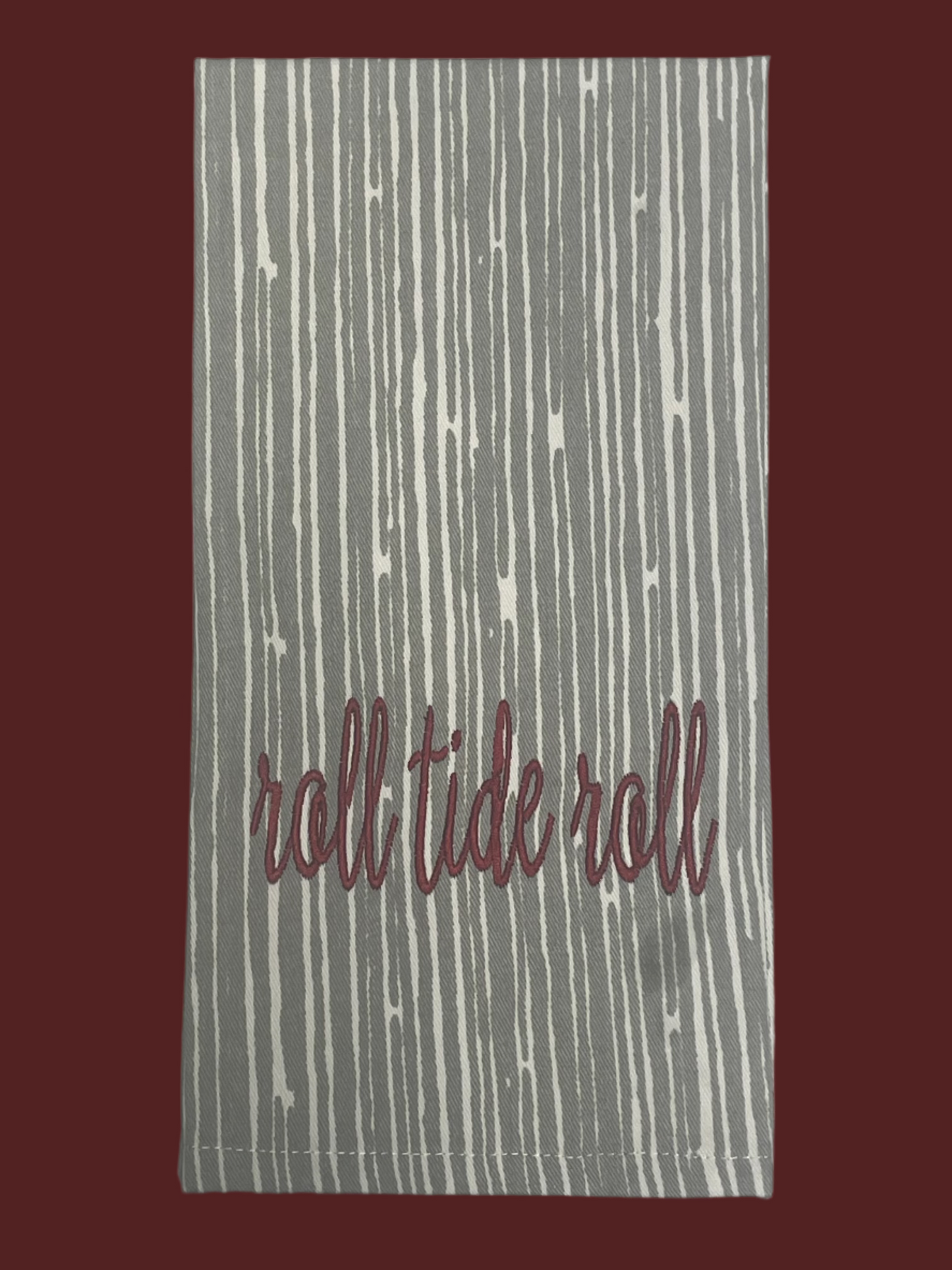 Hand towel featuring embroidered "Roll Tide Roll" text in crimson on gray and white vertical stripe pattern, perfect for Alabama fans and college football decor.