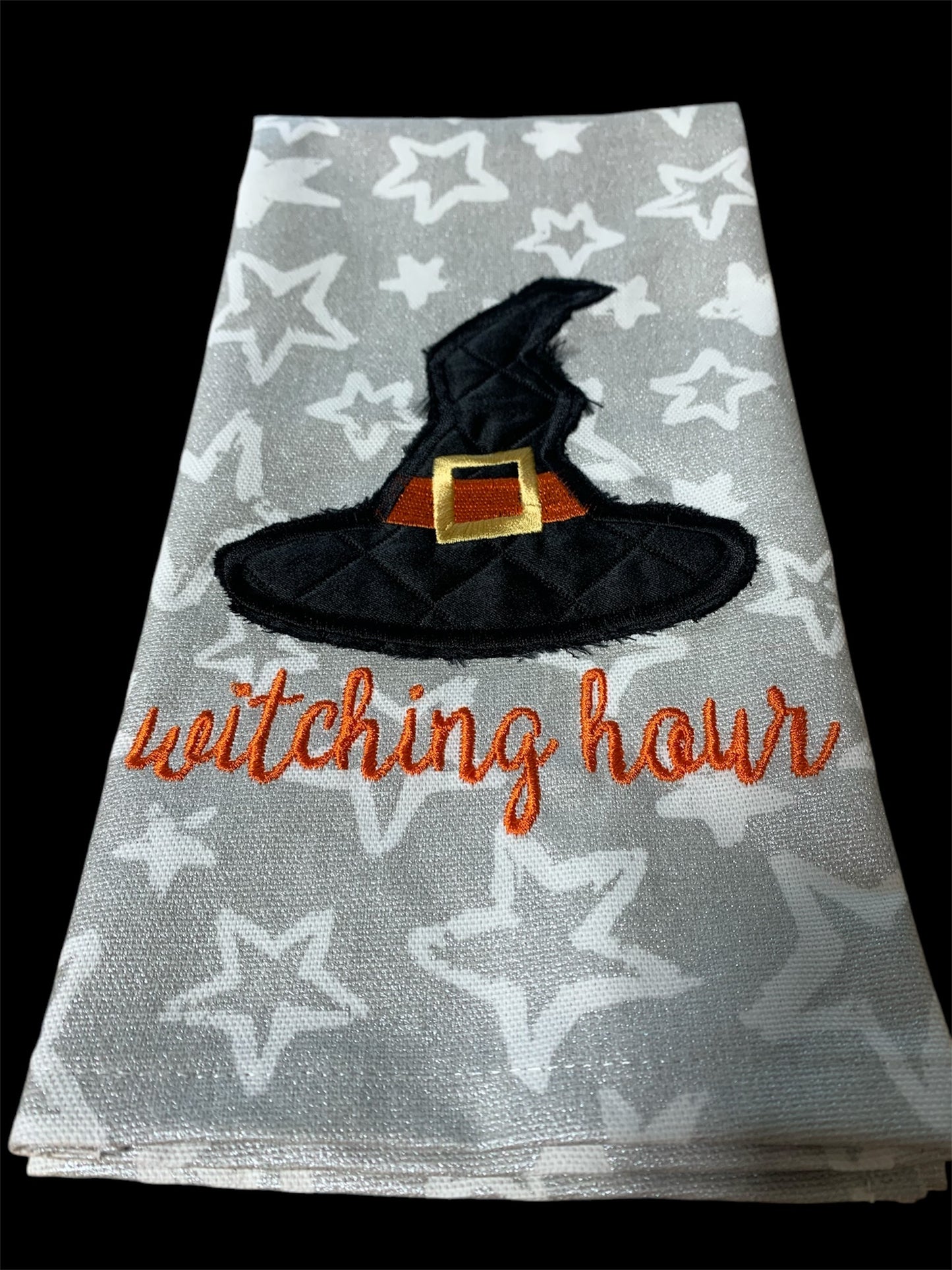 Decorative hand towel with embroidered witch hat and “Witching Hour” text on star-patterned background, perfect for Halloween and spooky seasonal decor.