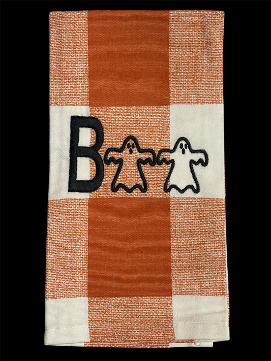 Halloween hand towel with embroidered "Boo" design featuring playful ghost appliqués on orange and white buffalo plaid background, perfect for seasonal kitchen or party decor.