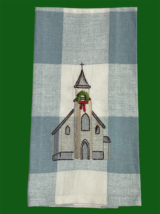 Decorative hand towel featuring embroidered church with Christmas wreath and bow on blue plaid background, perfect for holiday and winter seasonal home decor.