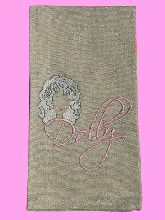 Decorative hand towel featuring embroidered silhouette of Dolly Parton with pink script text, perfect for country music fans, Southern kitchen decor, or gift giving.