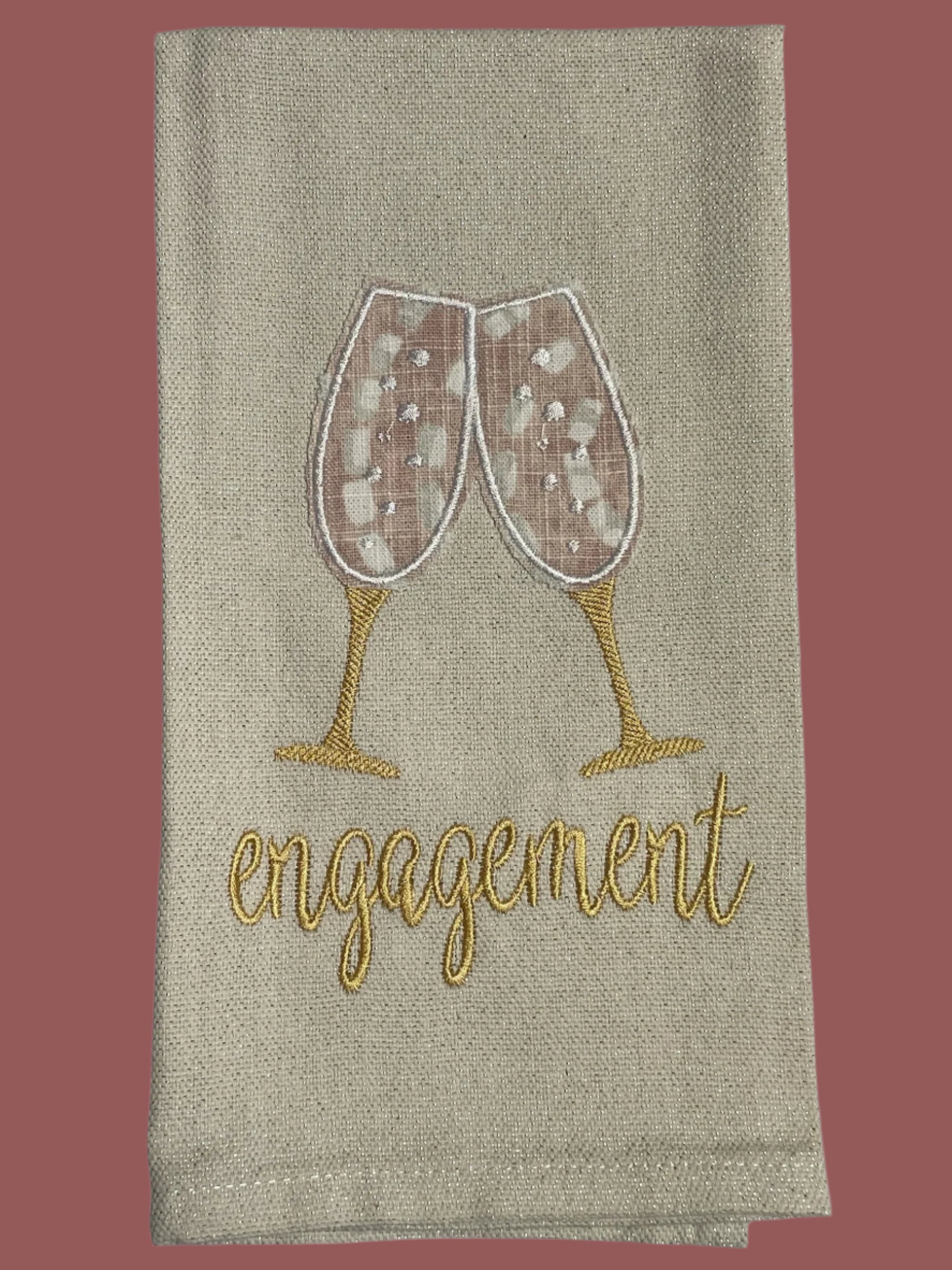 Decorative hand towel with embroidered champagne glasses and engagement text, perfect for engagement parties, bridal showers, and wedding gifts.