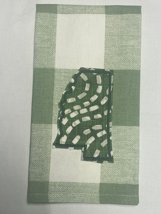 Decorative hand towel featuring embroidered Mississippi state outline with green and white abstract pattern on green plaid background, perfect for southern home decor and state pride gifts.