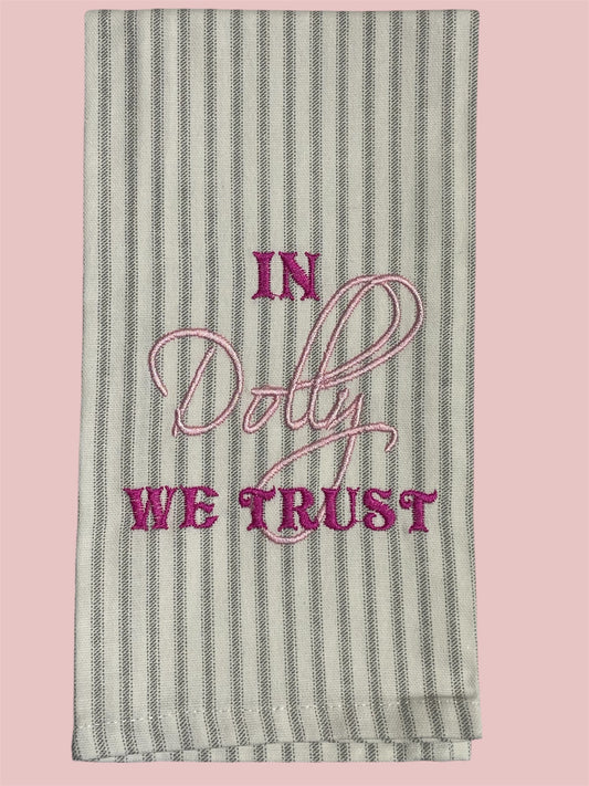 Striped decorative hand towel with embroidered text "In Dolly We Trust" in pink and magenta thread, perfect for Dolly Parton fans, Southern decor, and unique kitchen accents.