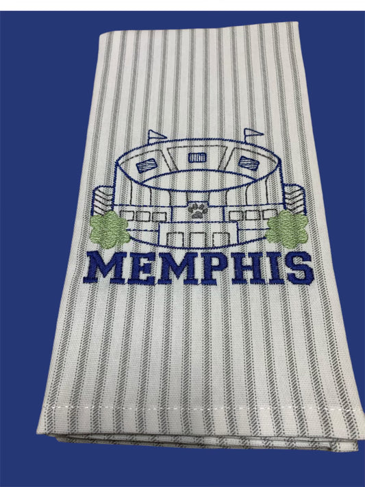 White towel with thin gray vertical stripes featuring a blue embroidered Memphis stadium design with trees and the word "MEMPHIS" underneath.