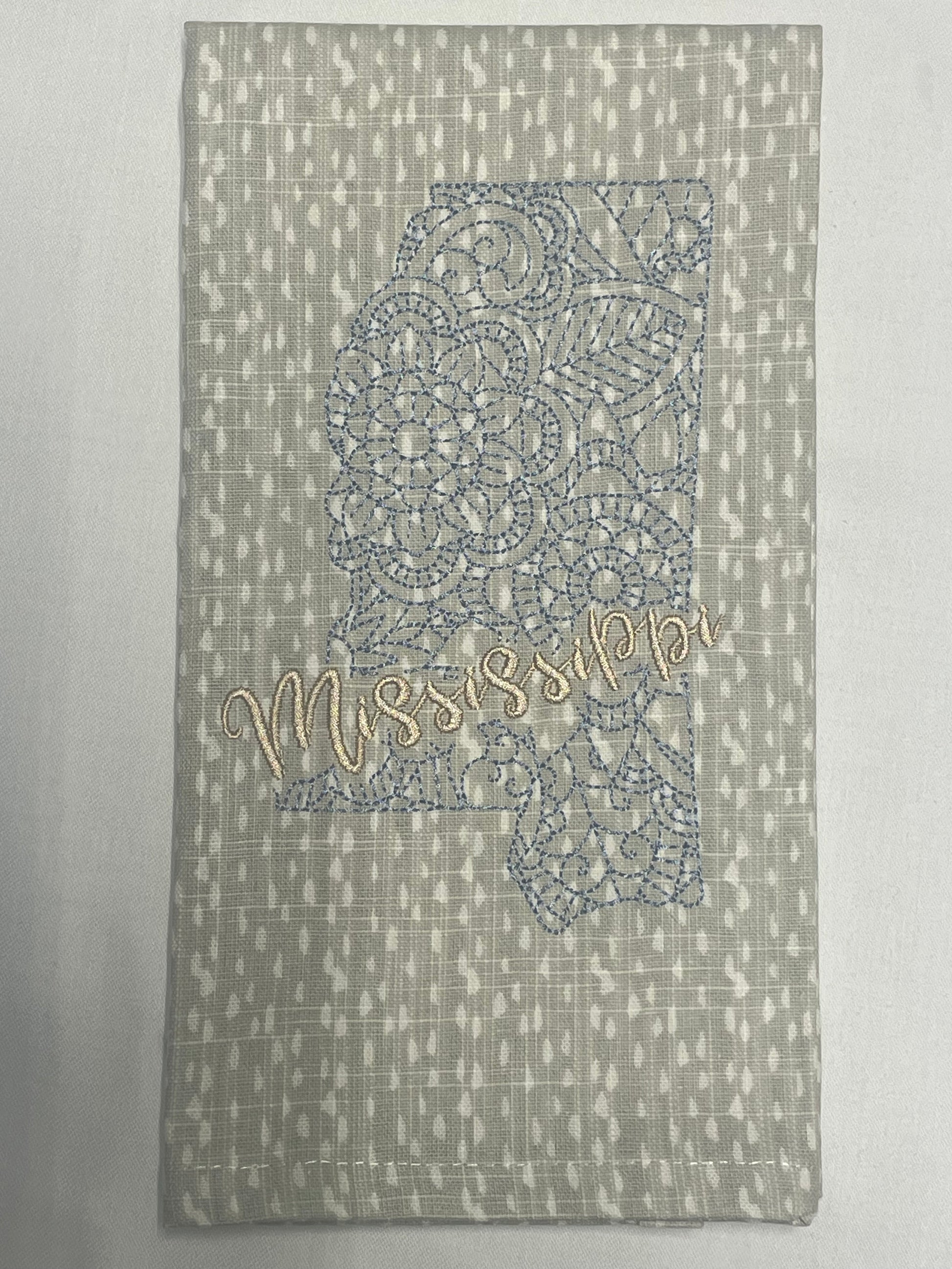 Decorative hand towel featuring embroidered Mississippi state outline with lace pattern and “Mississippi” script text, perfect for southern home decor and state pride gifts.