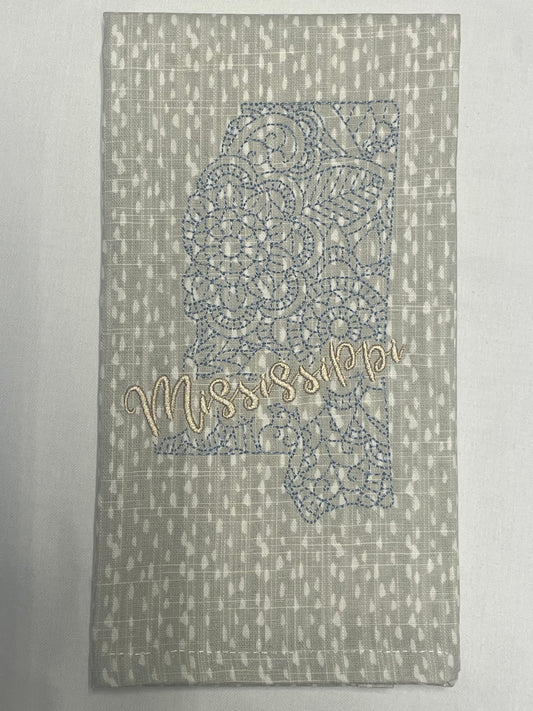 Decorative hand towel featuring embroidered Mississippi state outline with lace pattern and “Mississippi” script text, perfect for southern home decor and state pride gifts.