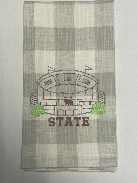 Decorative hand towel featuring embroidered Mississippi State stadium design with maroon "STATE" lettering on neutral plaid background, perfect for MSU fans, game day decor, or college sports gifts.