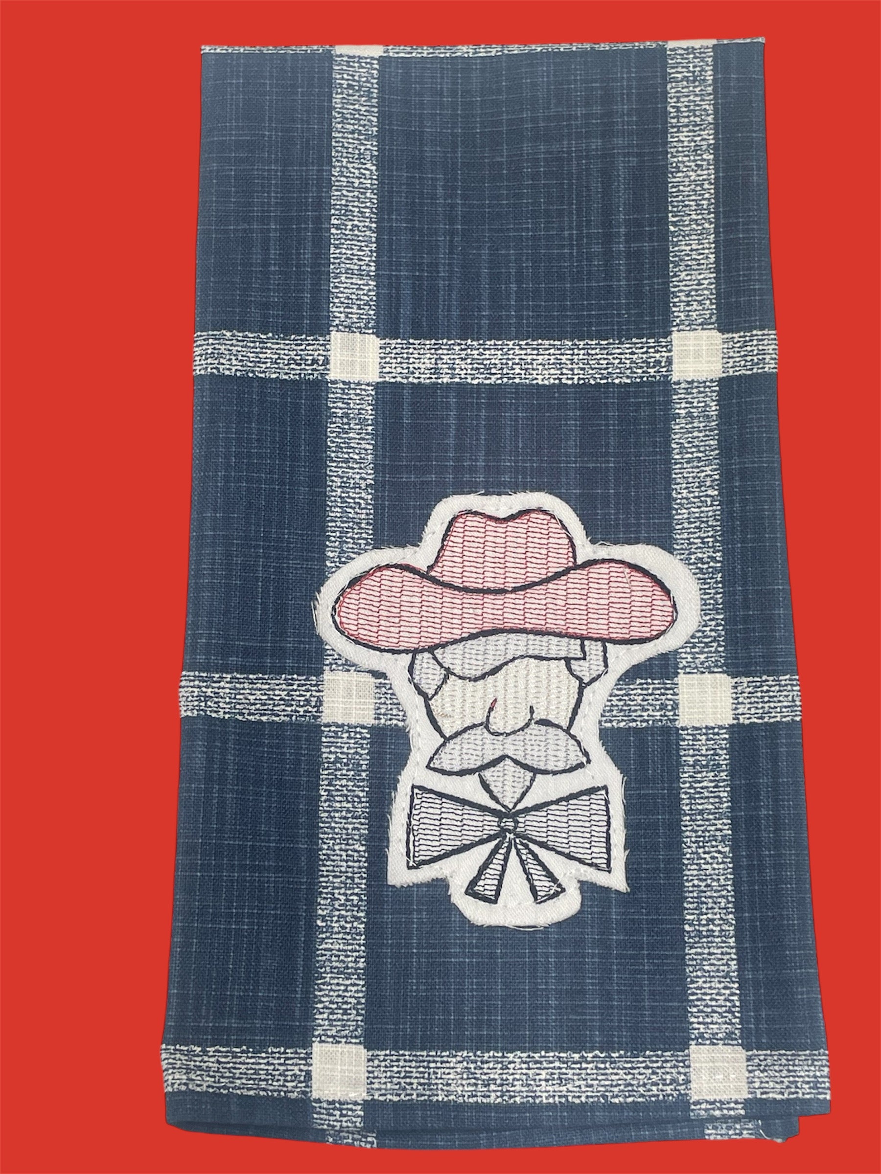 Decorative hand towel featuring embroidered Colonel Rebel mascot in pink and white on a navy blue plaid background, perfect for Ole Miss fans and Southern home decor.