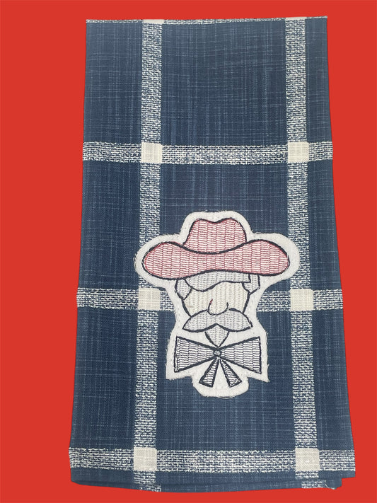 Decorative hand towel featuring embroidered Colonel Rebel mascot in pink and white on a navy blue plaid background, perfect for Ole Miss fans and Southern home decor.