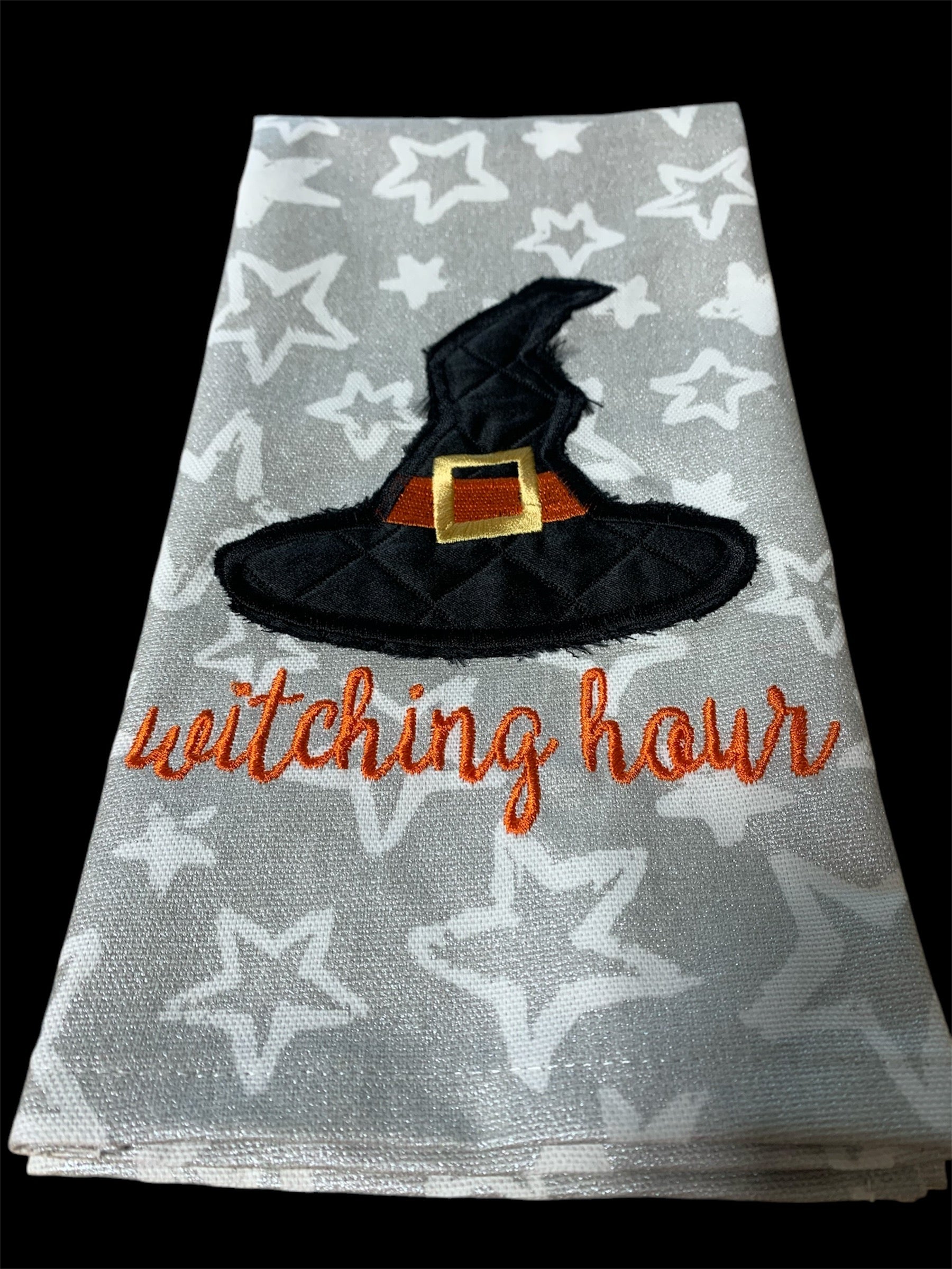 Decorative hand towel with embroidered witch hat and “Witching Hour” text on star-patterned background, perfect for Halloween and spooky seasonal decor.